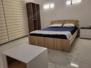 een slaapkamer met een bed en een witte tafel bij Jordanovi Premium Apartment in Kavadarci