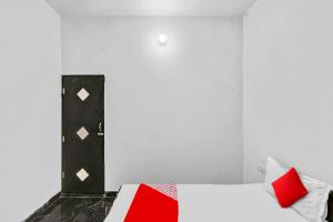 biały pokój z łóżkiem z czerwonymi poduszkami w obiekcie OYO Flagship 81043 Paradise Inn w mieście Panchli