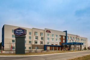 un bâtiment d'hôtel avec un panneau devant lui dans l'établissement Hampton Inn & Suites Adrian, Mi, à Adrian