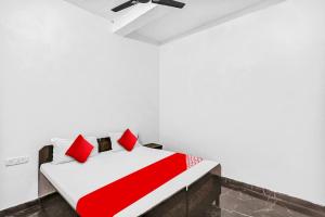 sypialnia z czerwono-białym łóżkiem i wentylatorem sufitowym w obiekcie OYO Flagship 81043 Paradise Inn w mieście Panchli