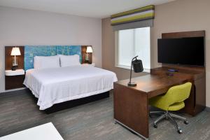Habitación de hotel con cama, escritorio y TV. en Hampton Inn & Suites Adrian, Mi, en Adrian