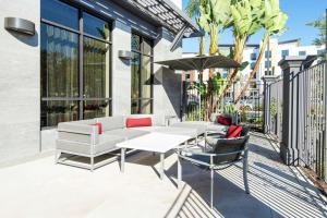 a patio with a couch and chairs and an umbrella at Hilton Garden Inn Irvine Spectrum Lake Forest in Lake Forest
