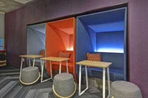 a room with two tables and two stools at Tru By Hilton Fort Worth Fossil Creek in Fort Worth