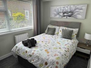 um quarto com uma cama com um bicho de peluche em Comfortable ground floor, 2 BR modern Apartment em Broadheath