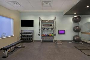 een kamer met een fitnessruimte met een televisie en gewichten bij Tru By Hilton Fort Worth Fossil Creek in Fort Worth