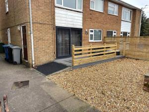 a wooden bench in front of a brick building at Comfortable ground floor, 2 BR modern Apartment in Broadheath