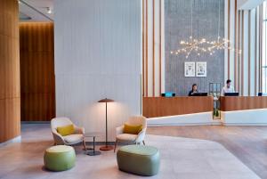 a lobby with two chairs and a reception desk at Hilton Garden Inn Kuwait in Kuwait
