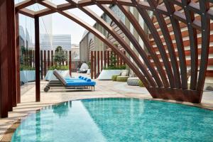 uma piscina com uma pérgula ao lado de um pátio em Hilton Garden Inn Kuwait em Kuwait