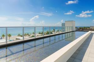 a view of the pool and beach from the balcony of a resort at New! Beach Access with Rooftop Pool in Hollywood