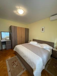 a bedroom with a large bed and a bathroom at Rooms Krstinić 84 in Palit +7 photos