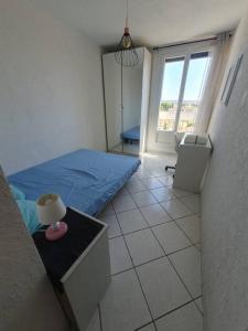 Habitación pequeña con cama y ventana en Appart 70m² plein sud, en Marignane
