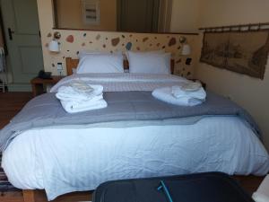 1 dormitorio con 1 cama con toallas en Suite Korfes-Κορφές-Σ Αυτόνομη Σουίτα με Τζάκι στην Βίλα Κορφές, en Karpenisi