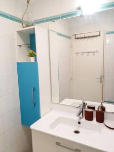 uma casa de banho branca com um lavatório e um espelho em Appart 70m² plein sud em Marignane