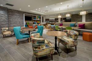 ein Restaurant mit Tischen und Stühlen und einer Couch in der Unterkunft Home2 Suites By Hilton Grove City Columbus in Grove City