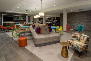vestíbulo con sofá, sillas y mesas en Home2 Suites By Hilton Grove City Columbus, en Grove City