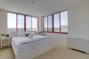 a white bedroom with a large bed and windows at Gorgeous Apt with Rooftop City View @Pentagon City in Arlington