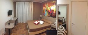 um pequeno quarto com uma cama e um espelho em B&B Le Vibrazioni em Roma
