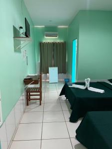 a room with two beds and a table and a chair at Hotel Legal in Capanema +28 photos