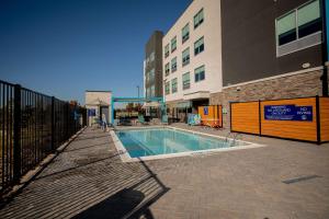 a swimming pool in front of a building at Tru By Hilton The Colony in The Colony