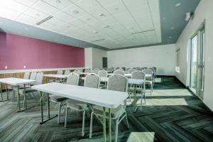 a room with tables and chairs and a purple wall at Tru By Hilton The Colony in The Colony +24 photos