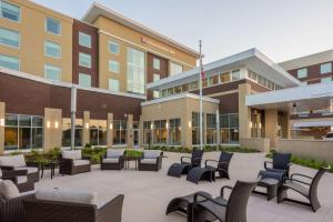 a courtyard with chairs and tables in front of a building at Hilton Garden Inn Memphis East/Germantown, Tn in Memphis