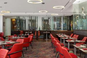 丹佛The Art Hotel Denver, Curio Collection by Hilton的有桌子和红色椅子的餐厅