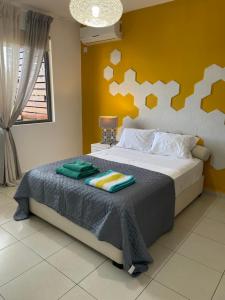 a bedroom with a bed with a yellow wall at Beautiful 3 rooms apartment, 2 beds & 1 dressing room in Flic-en-Flac +24 photos