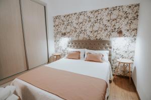 Apartamentos Turaca في تروخيلو: غرفة نوم مع سرير كبير مع وسادتين ورديتين