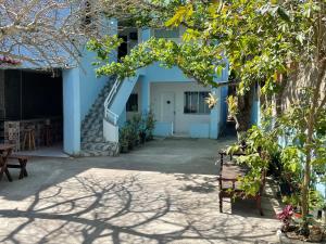 un edificio azul con puerta blanca y patio en SUITEs E FLATs MONTE ALTO ARRAIAL DO CABO en Arraial do Cabo