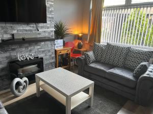 a living room with a couch and a fireplace at WV1 Bridge House - 3 Bedrooms, sleeps 6 free Parking - New Cross - Bentley Bridge - 欢迎 in Wolverhampton
