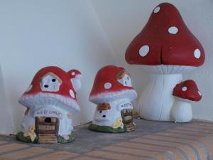 a group of red and white mushrooms with a house at NINEMIA in Amfilochía