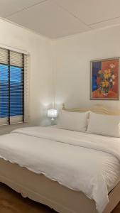 duże białe łóżko w białej sypialni z oknem w obiekcie Rynn Hotel w mieście Trat