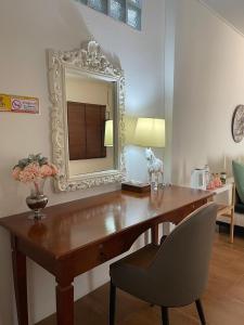a wooden desk with a mirror and a chair at Rynn Hotel in Trat