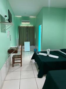 - une chambre avec deux lits, un bureau et une chaise dans l'établissement Hotel Legal, à Capanema