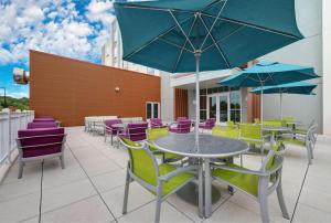 a patio with colorful chairs and tables and umbrellas at Hilton Garden Inn Manassas in Manassas