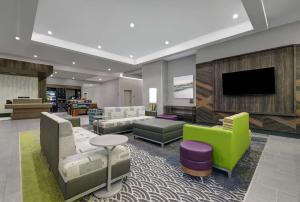 a lobby with couches and a flat screen tv at Hilton Garden Inn Manassas in Manassas