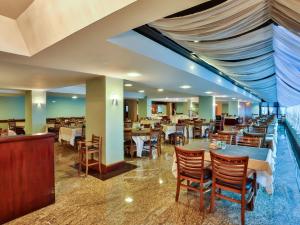 a restaurant with tables and chairs in a room at Flat Acolhedor para 5 Pessoas em Campos do Jordão in Campos do Jordão