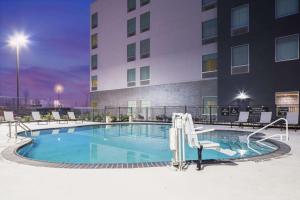 a swimming pool in front of a building at Homewood Suites by Hilton DFW Airport South, TX in Fort Worth