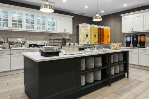 a kitchen with a large island with plates on it at Homewood Suites by Hilton DFW Airport South, TX in Fort Worth