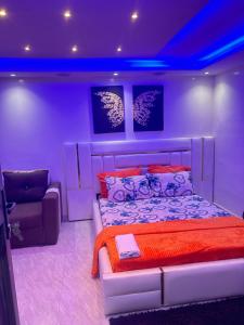 Habitación púrpura con cama y silla en Paryssonalo en Dakar