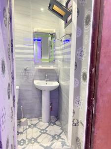 La salle de bains est pourvue d'un lavabo et d'un miroir. dans l'établissement Paryssonalo, à Dakar