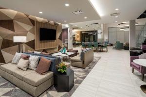 a lobby with a couch and chairs and a table at Hilton Garden Inn Albuquerque Downtown, Nm in Albuquerque