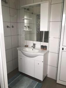 bagno bianco con lavandino e specchio di Villa Vicente a Vila Nova Sintra