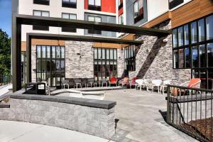 un patio con mesas y sillas frente a un edificio en Hilton Garden Inn Bel Air, Md, en Bel Air