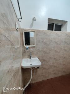 a bathroom with a sink and a window at Surya cafe and stay sea view in Gokarna