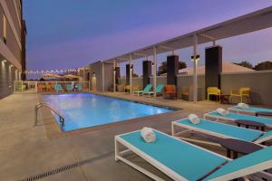 Home2 Suites By Hilton Vicksburg, Ms في فيكسبيرغ: مسبح في فندق به طاولات وكراسي