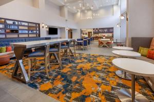 ein Esszimmer mit Tischen, Stühlen und einem Teppich in der Unterkunft Hampton Inn & Suites Bloomfield Hills Detroit in Bloomfield Hills