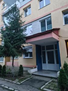 une maison avec un arbre en face dans l'établissement Apartament modern-nou Cristina&Jessica, à Mediaş