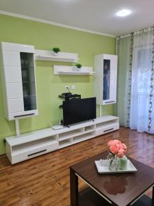 - un salon avec une télévision et une table dans l'établissement Apartament modern-nou Cristina&Jessica, à Mediaş