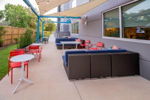 a patio with red chairs and tables and chairs at Tru By Hilton Niceville, Fl in Niceville